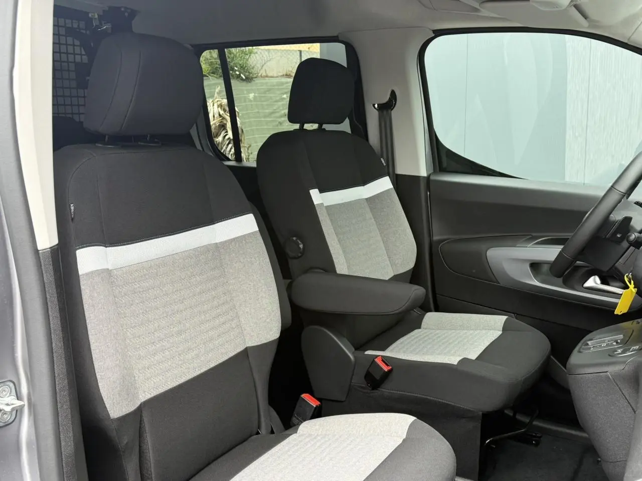 Vue intérieure côté droit du Citroën Berlingo Multispace 2026, sièges avant bicolores gris et noir avec accoudoir.