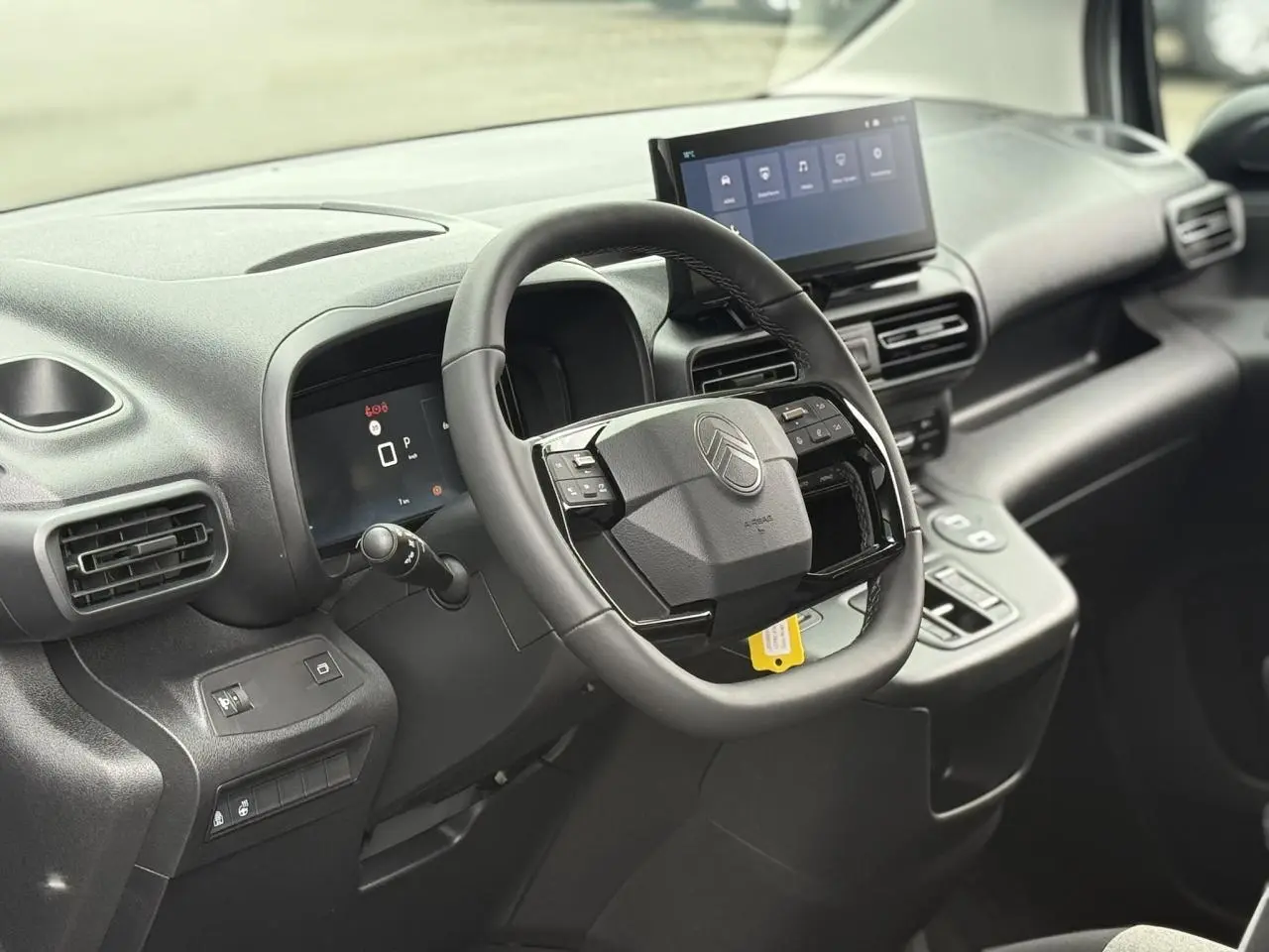 Vue intérieure du poste de conduite du Citroën Berlingo Multispace 2026, volant multifonctions et écran tactile central.