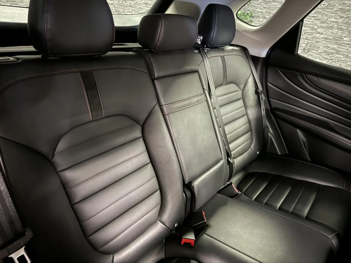Vue intérieure du siège arrière cuir noir avec surpiqûres rouges du MG MOTOR EHS 1.5T Luxury 2022.