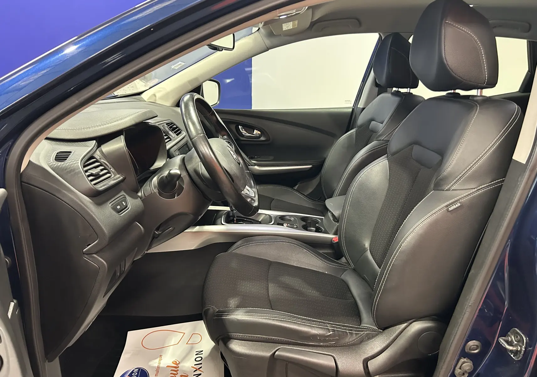 Intérieur du Renault Kadjar TCe 130 Intens 2017, vue côté conducteur, sièges noirs en cuir et tissu, tableau de bord moderne.