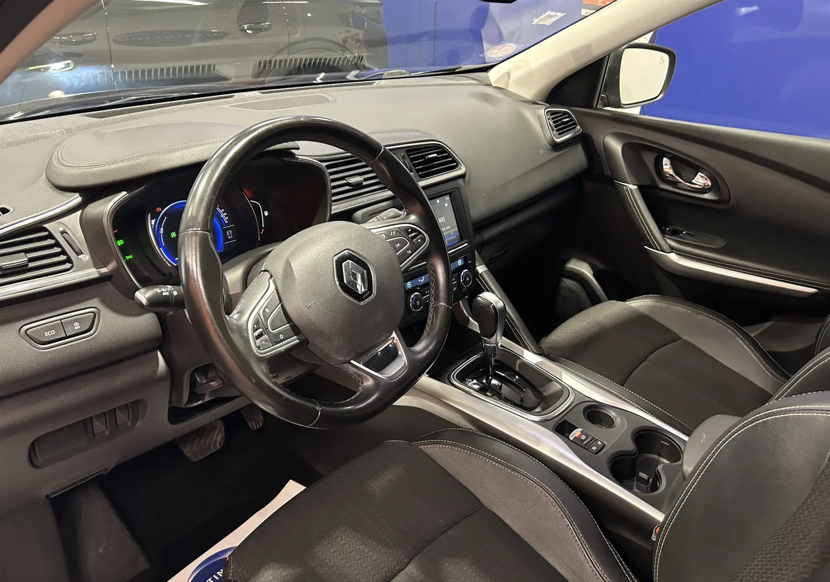 Intérieur du Renault Kadjar TCe 130 Intens 2017, vue côté conducteur sur le tableau de bord et la console centrale noire.