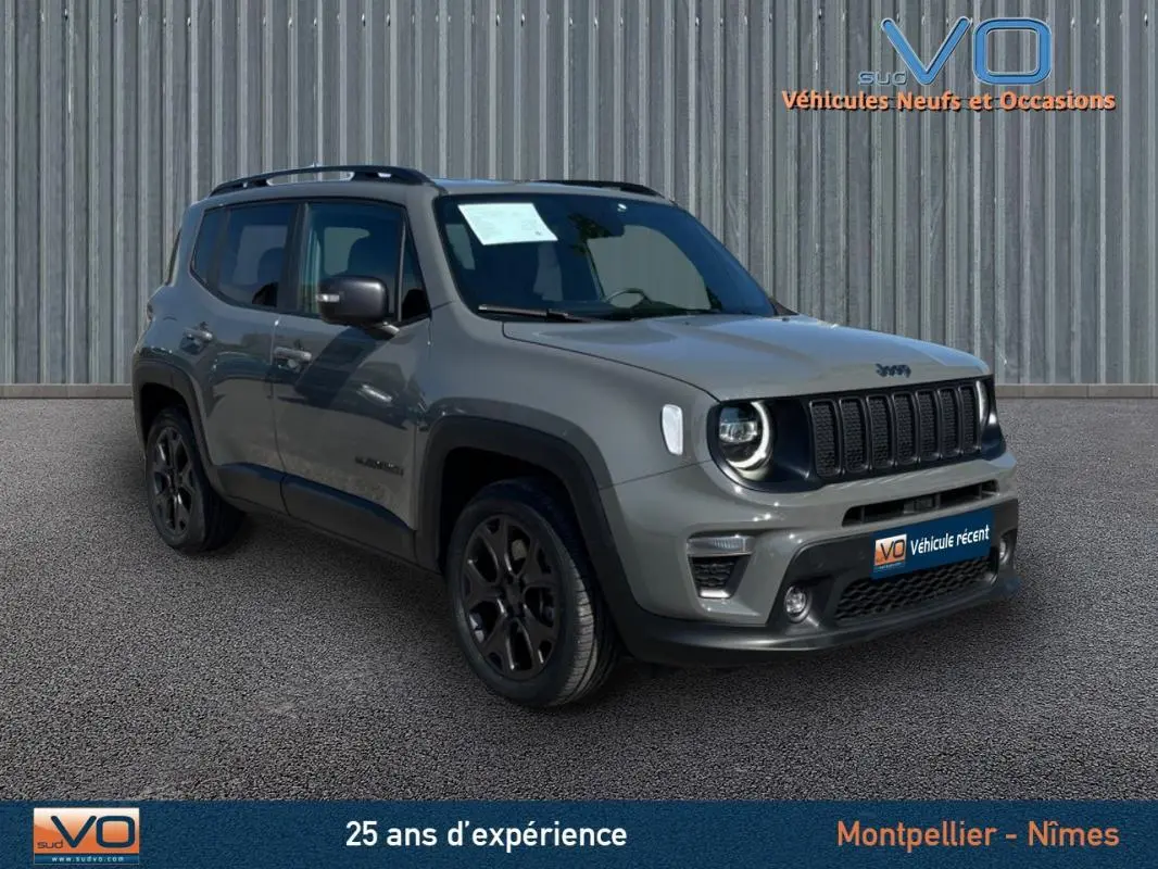 Jeep Renegade gris foncé vu en 3/4 avant droit avec barres de toit et jantes alliage noires.