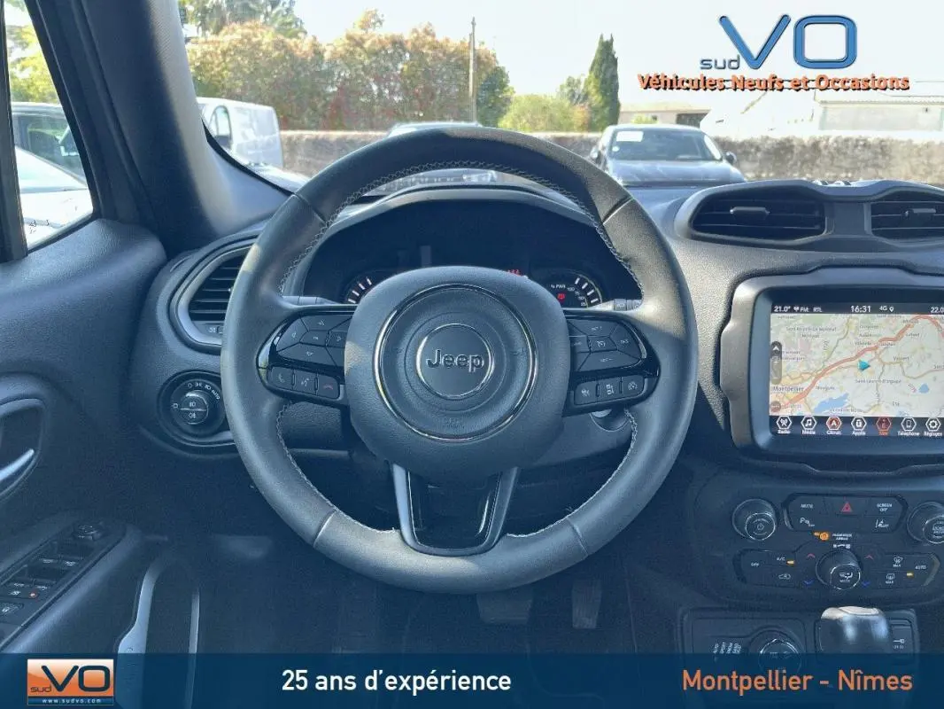 Vue intérieure centrée sur le volant Jeep noir avec tableau de bord et écran tactile affichant un GPS.