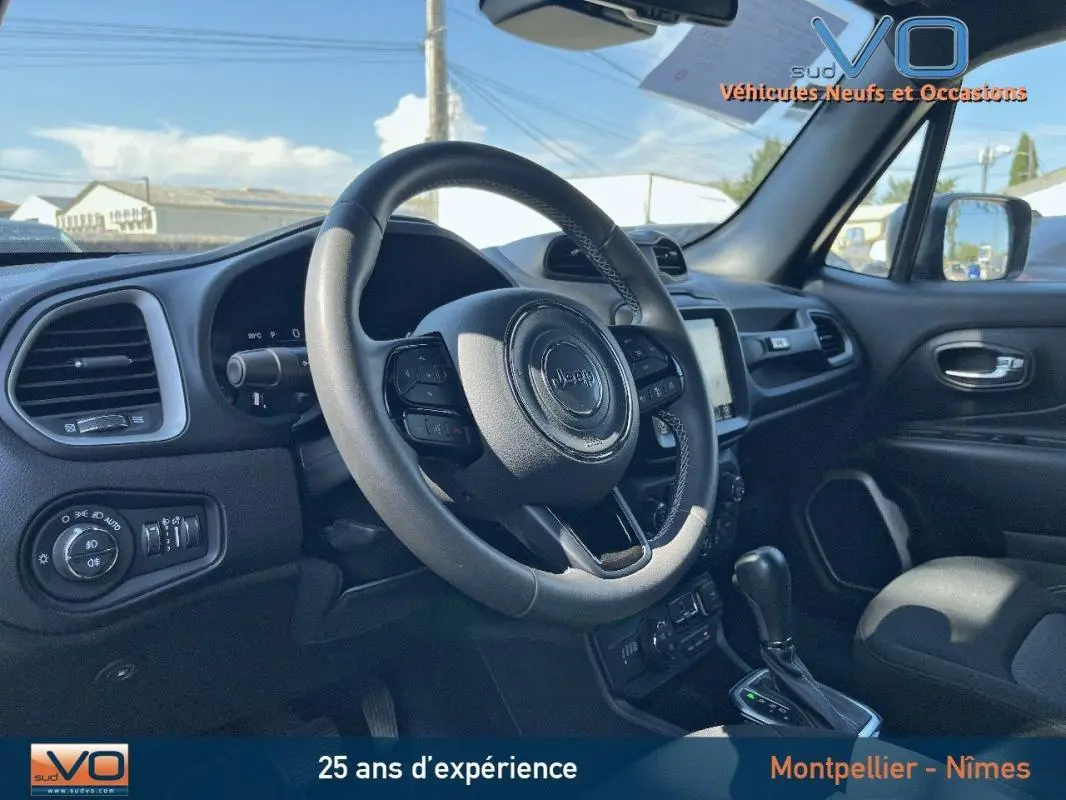 Intérieur du Jeep Renegade 2021 vu côté conducteur, volant cuir, écran tactile et tableau de bord moderne noirs.
