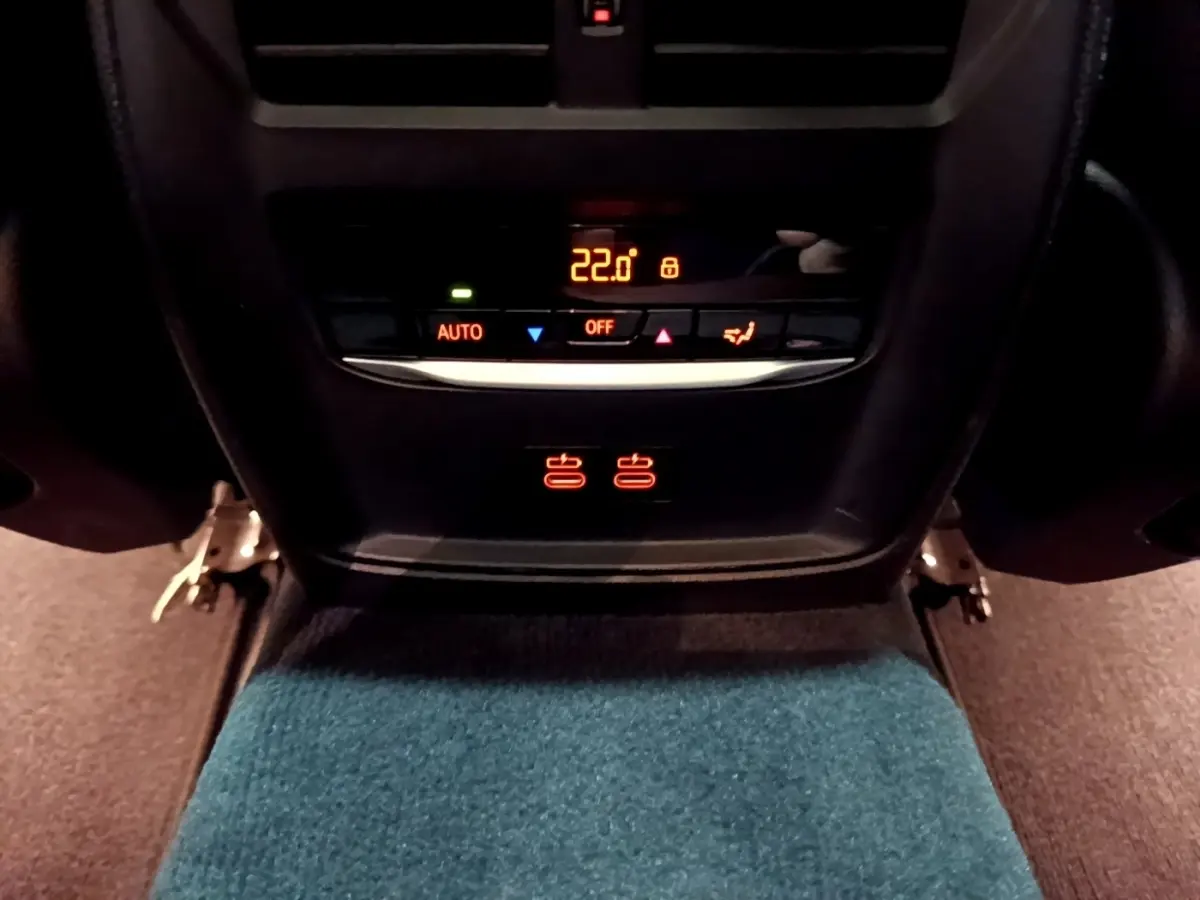 Panneau de commande de climatisation arrière avec affichage digital à 22°C dans une BMW Série 3 noire 318i M Sport.