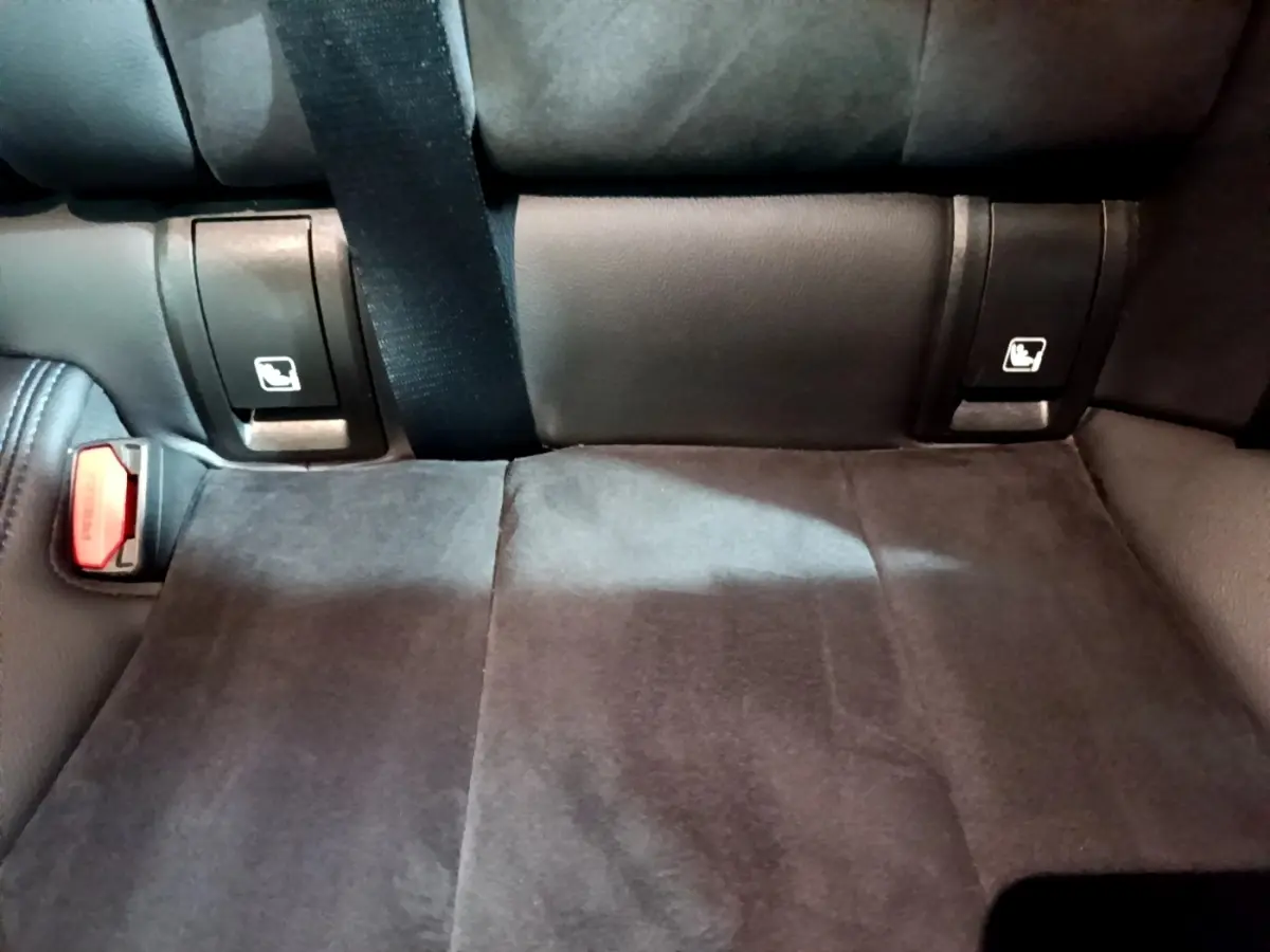 Détail de la banquette arrière noire de la BMW Série 3 318i M Sport avec ceintures et fixations Isofix visibles.