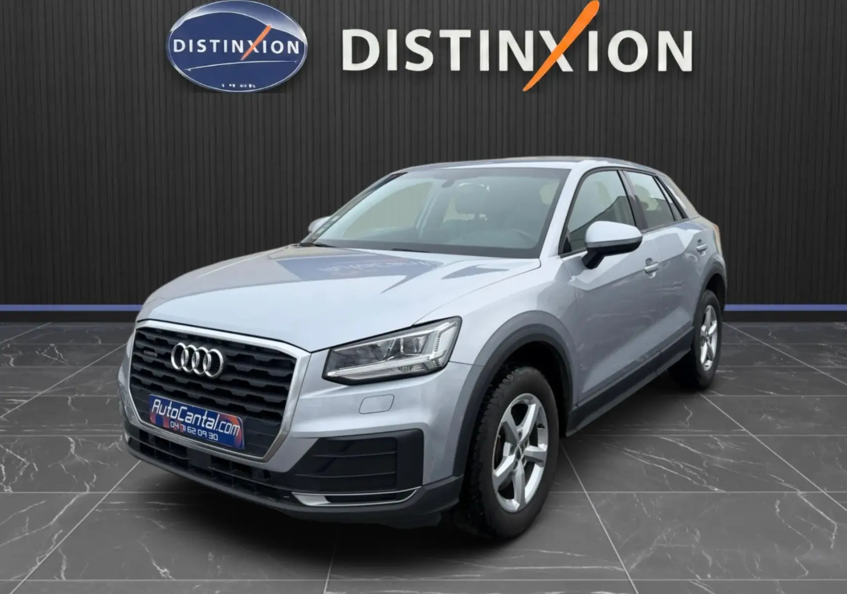 Audi Q2 gris aluminium en 3/4 avant droit, avec calandre noire et jantes alliage 5 branches visibles.