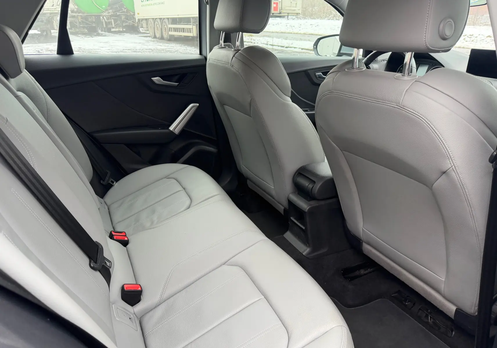 Vue intérieure arrière de l'Audi Q2 2017, sellerie similicuir gris clair avec sièges arrière et avant visibles.