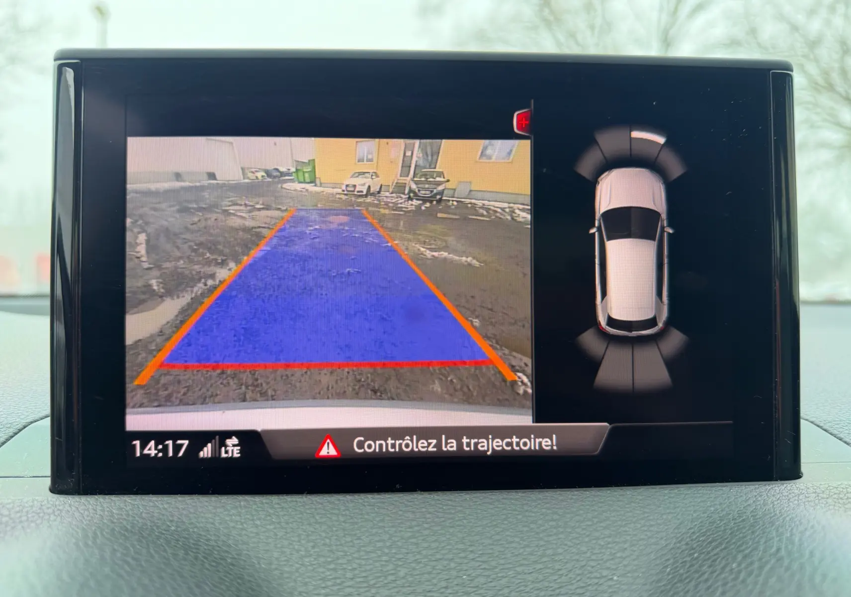 Écran de caméra de recul et vue 360° du tableau de bord de l'Audi Q2 gris aluminium en stationnement.