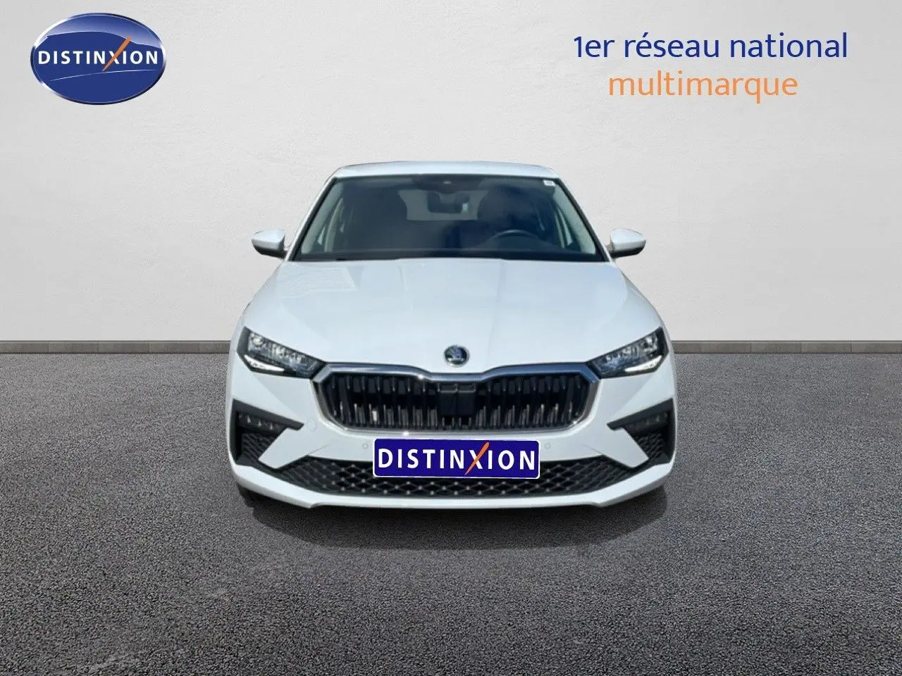Vue frontale d'une Skoda Scala blanc glacier avec calandre noire et phares LED distinctifs.