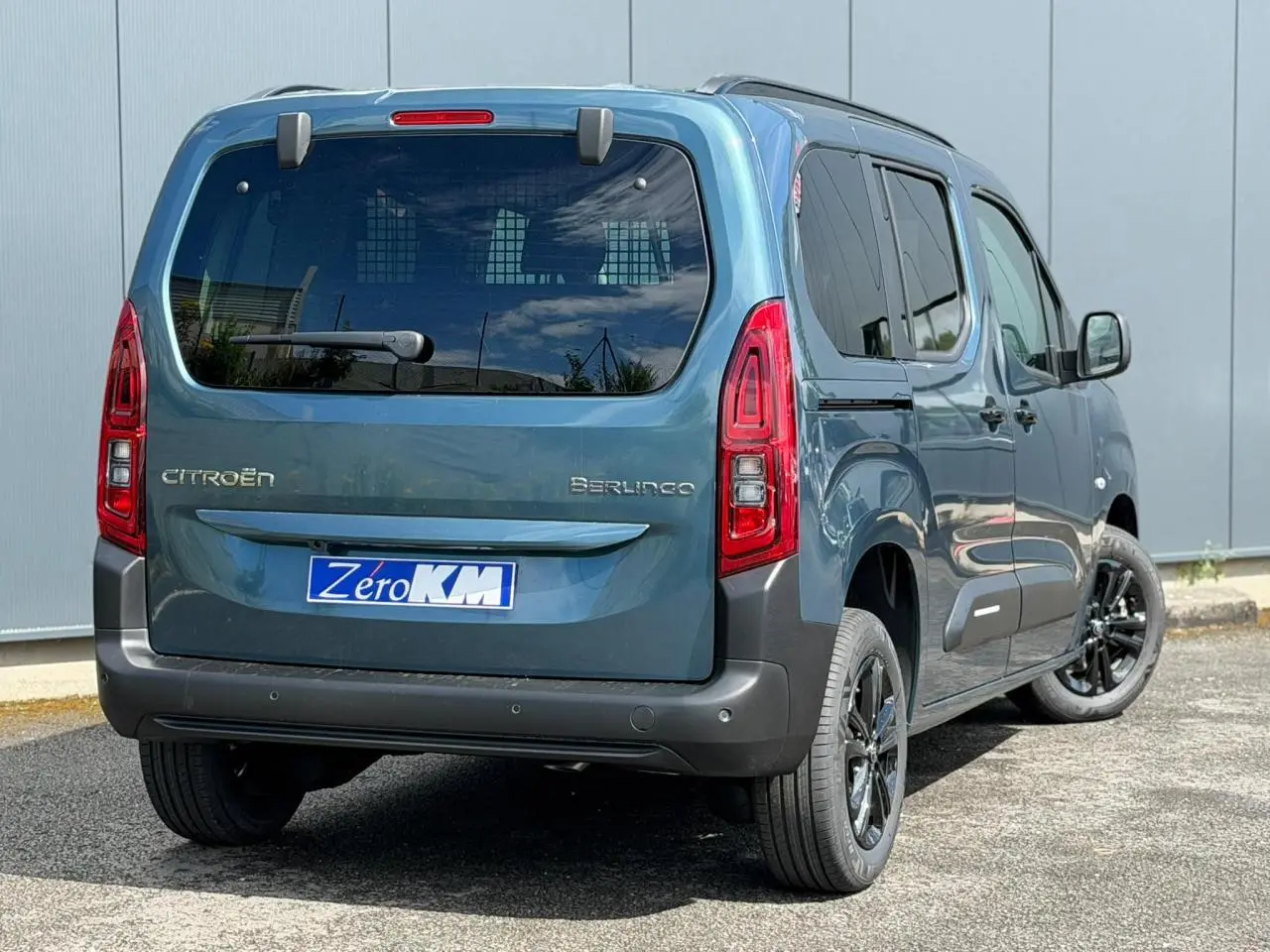 Vue 3/4 arrière droite du Citroën Berlingo Multispace bleu Kiama avec lunette arrière ouvrante et jantes alliage noires.