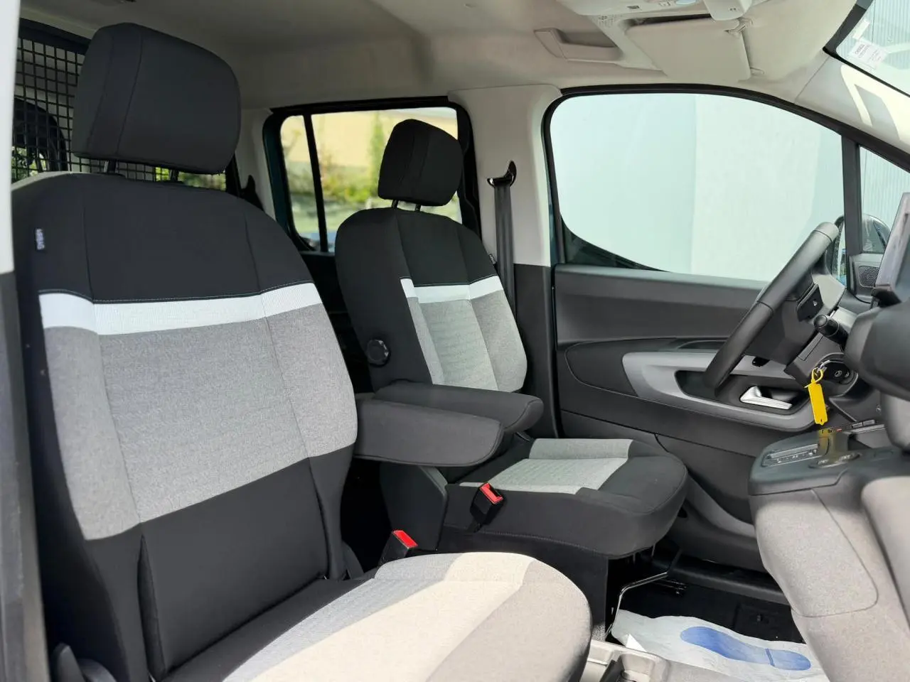 Vue intérieure côté droit du Citroën Berlingo Multispace 2026, sièges tissu gris et noir avec accoudoirs.