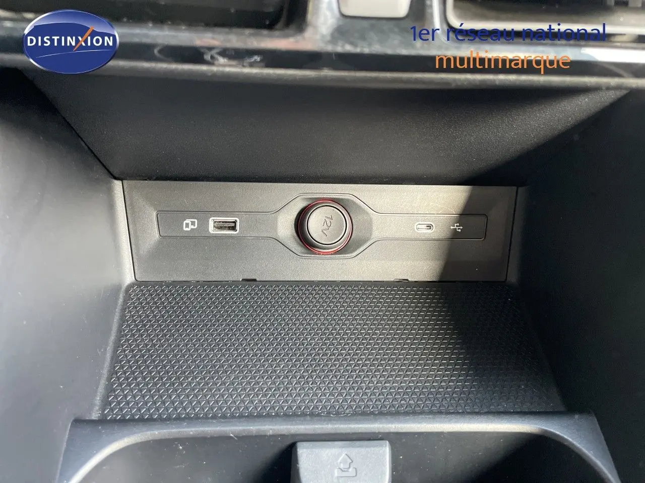 Détail de la console centrale du MG3 2024 montrant prise 12V et ports USB dans un intérieur noir.
