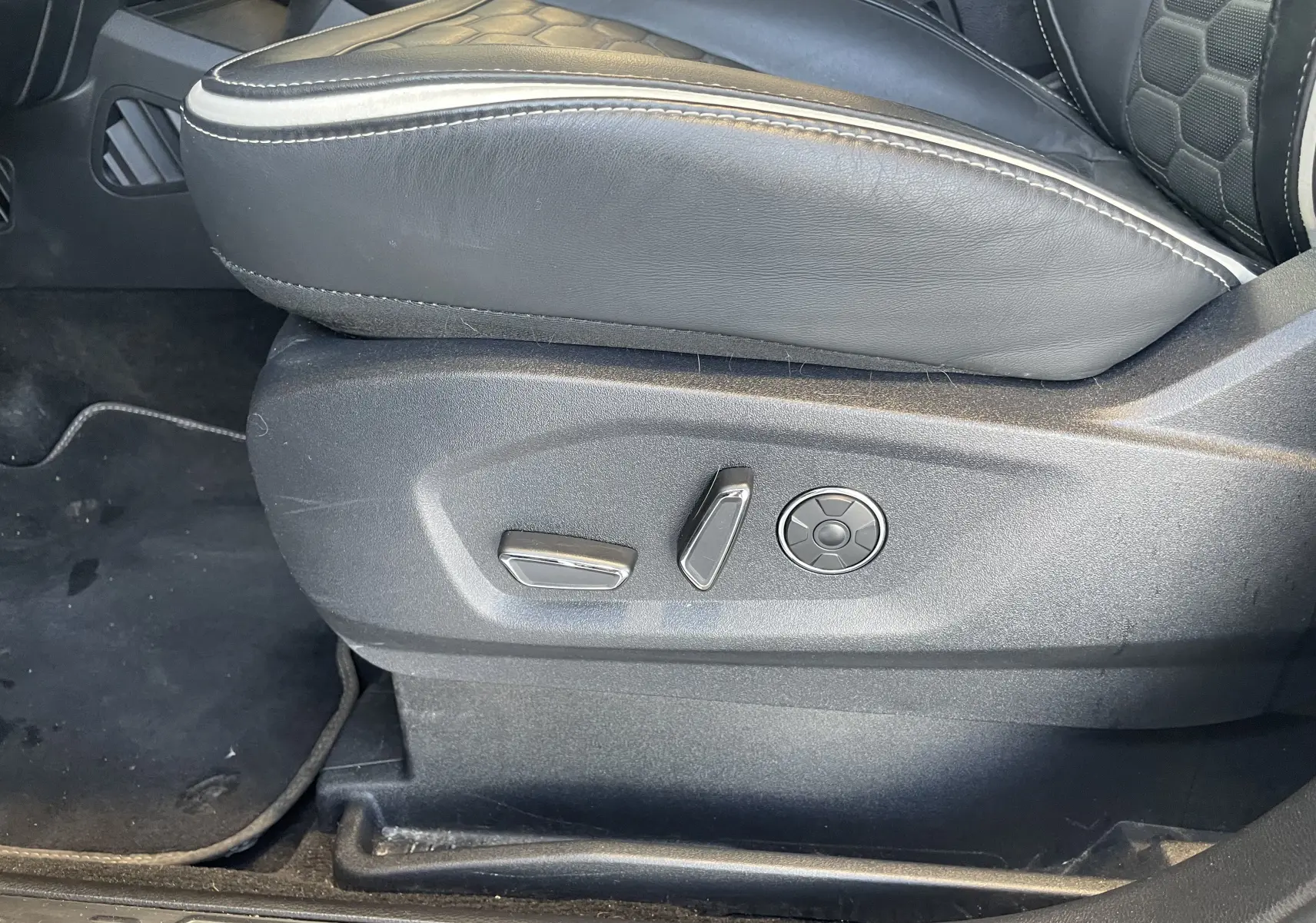 Gros plan sur les commandes électriques du siège avant gauche en cuir noir avec surpiqûres blanches du Ford S-MAX Vignale gris magnetic 2022.