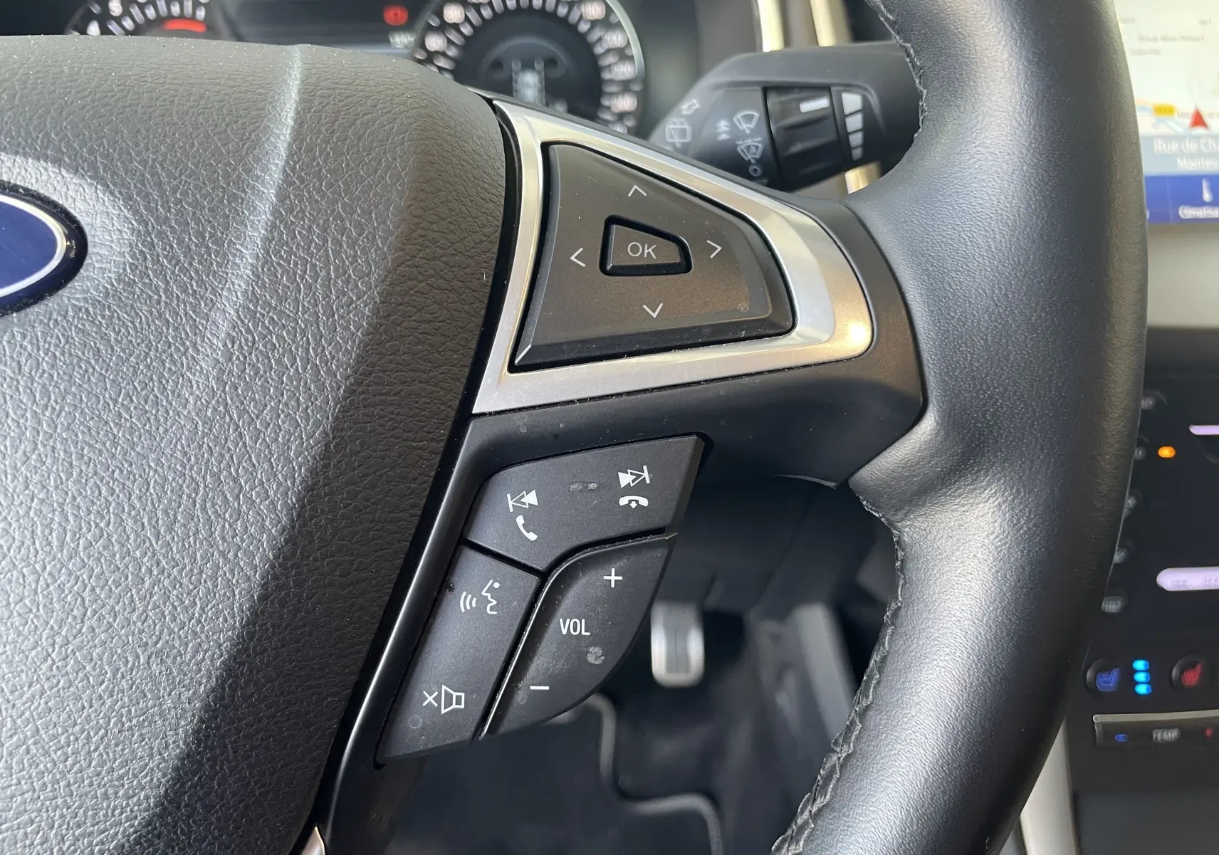 Gros plan sur les commandes multifonctions du volant en cuir noir du Ford S-MAX Vignale gris magnetic 2022.