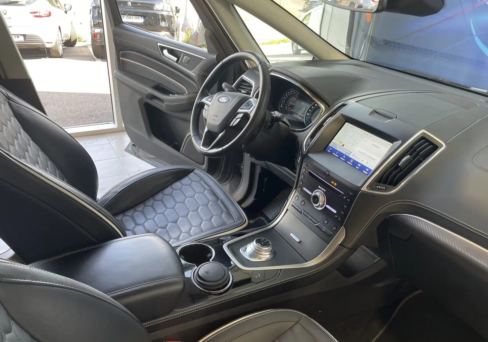 Vue intérieure côté conducteur du Ford S-MAX Vignale 2022, avec sièges en cuir noir matelassé et écran tactile central.