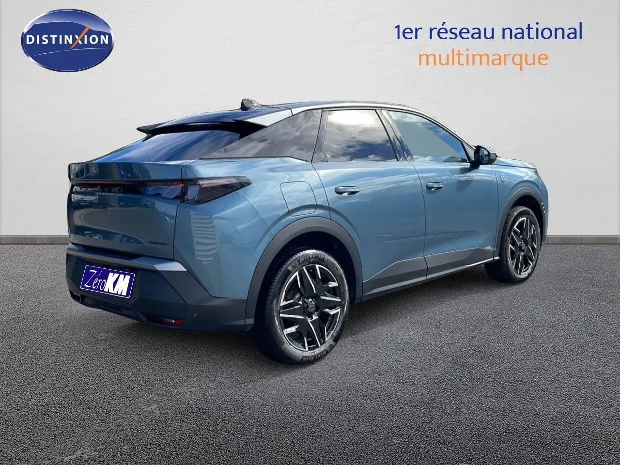 Peugeot 3008 hybride 2025 bleu Ingaro métal avec toit noir, vue 3/4 arrière côté gauche sur sol gris.
