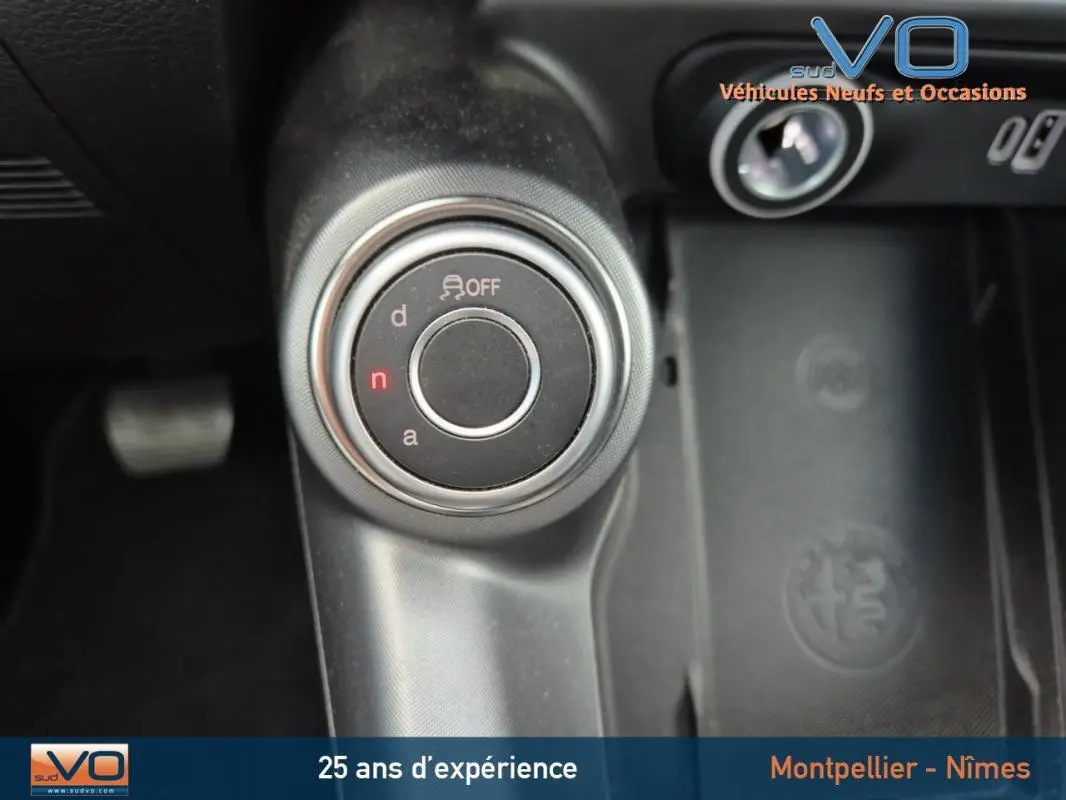 Gros plan sur la molette de sélection de mode de conduite dans l'Alfa Romeo Tonale gris 2023, intérieur noir.