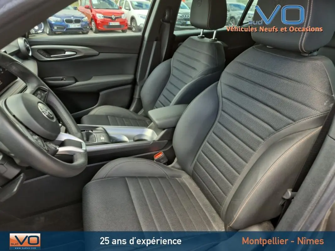 Intérieur de l'Alfa Romeo Tonale gris, vue côté gauche sur les sièges sport et le volant cuir avec surpiqûres.