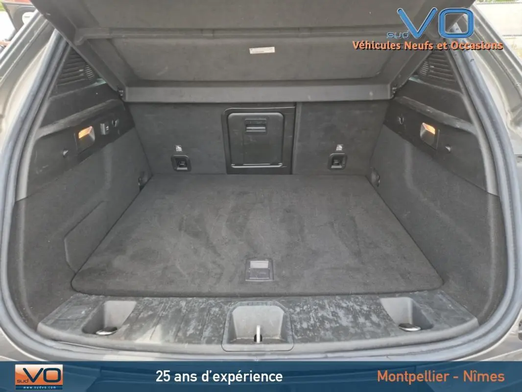 Coffre ouvert d'une Alfa Romeo Tonale gris 2023, montrant un espace de chargement propre et bien aménagé.