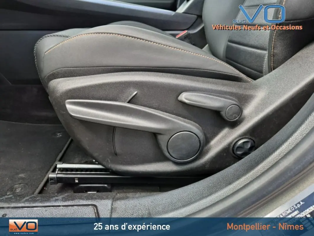 Vue rapprochée du côté gauche du siège avant gris de l'Alfa Romeo Tonale 2023 avec commandes manuelles visibles.