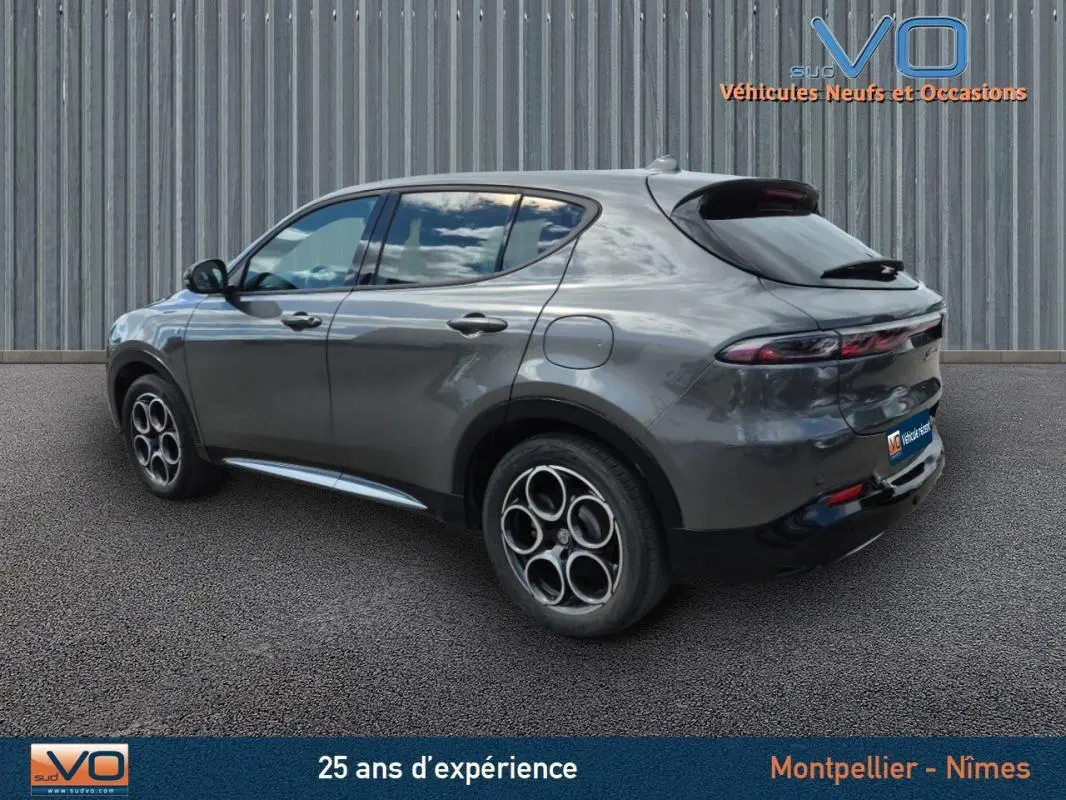 Vue 3/4 arrière côté gauche d'une Alfa Romeo Tonale grise avec jantes alliage 18 pouces et feux arrière effilés.