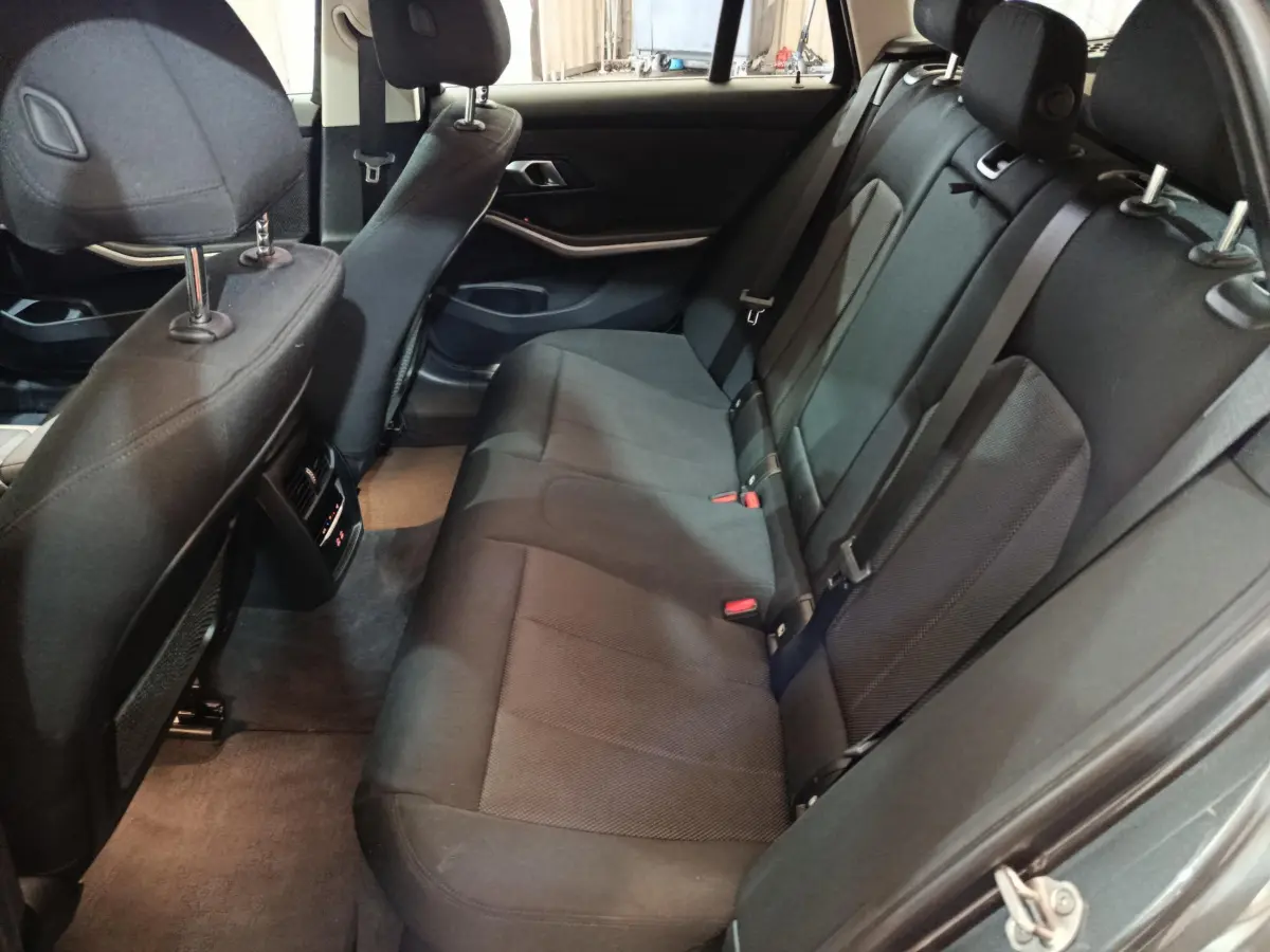 Vue intérieure côté droit sur la banquette arrière noire de la BMW Série 3 316d Business Design 2022.