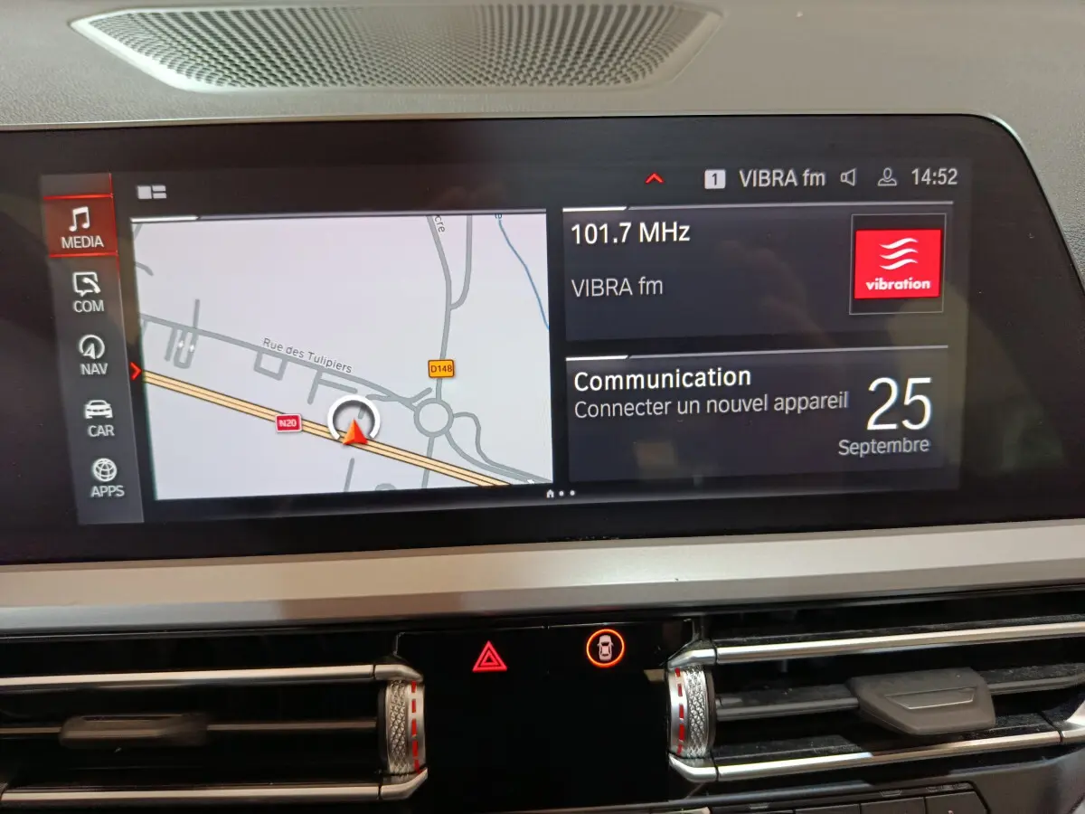 Écran tactile central de la BMW Série 3 316d 2022 affichant navigation et radio, avec commandes de climatisation visibles.