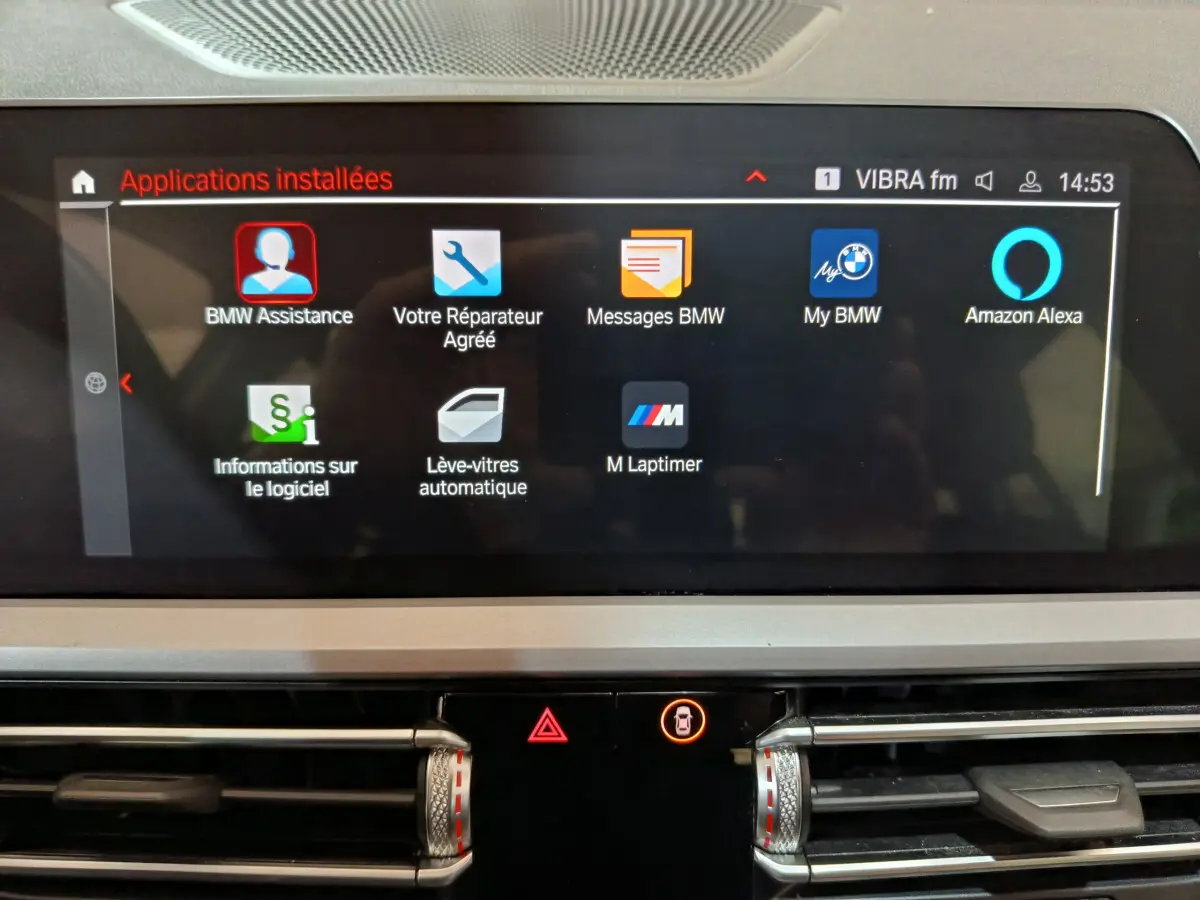 Écran tactile central affichant les applications BMW et Alexa dans l'habitacle d'une BMW Série 3 gris clair.