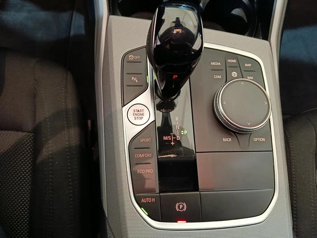 Vue rapprochée de la console centrale de la BMW Série 3 316d 2022 avec levier de vitesses et commandes multimodes.