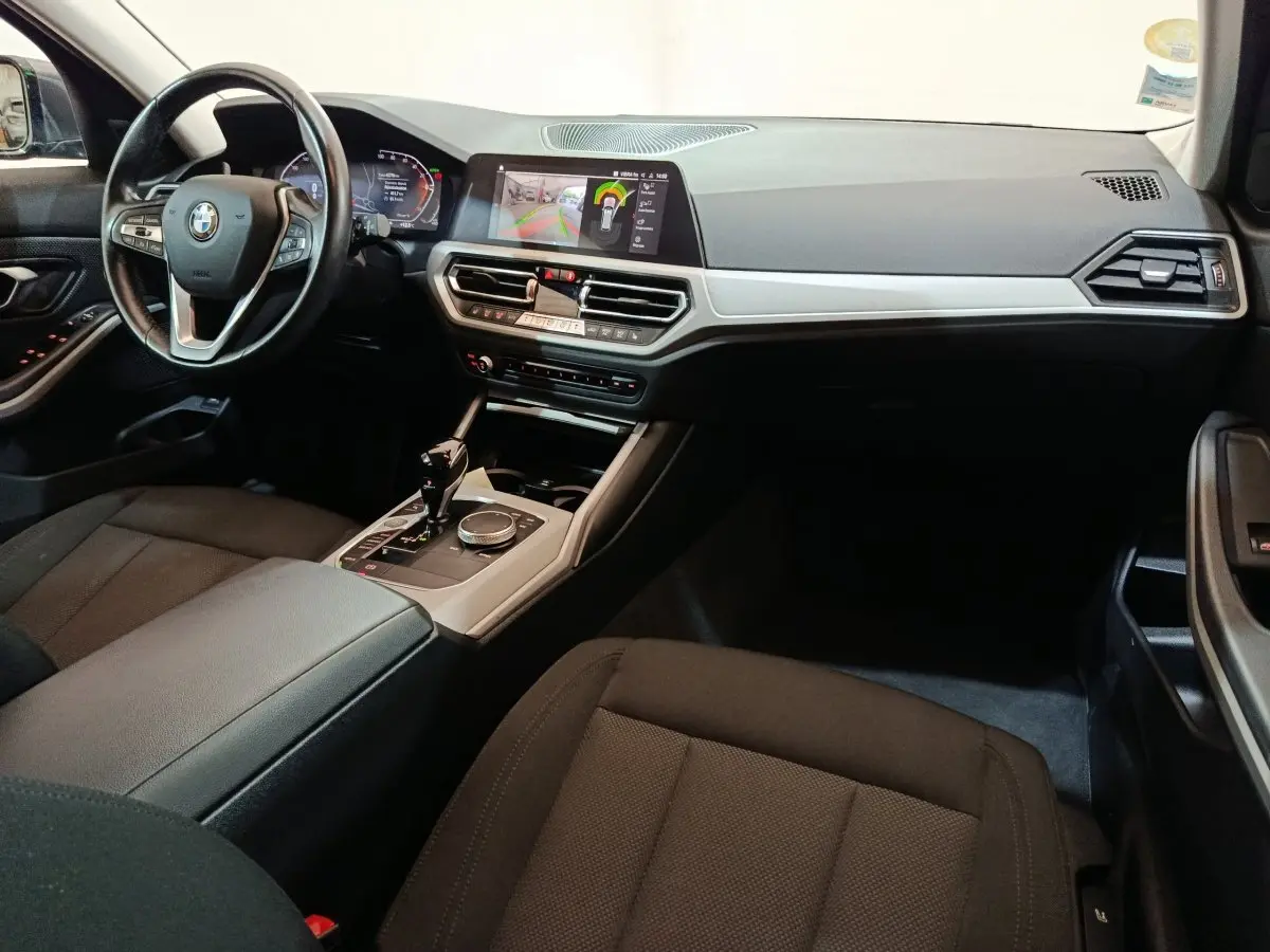 Intérieur avant droit de BMW Série 3 316d 2022, tableau de bord noir avec écran tactile et volant cuir multifonctions.