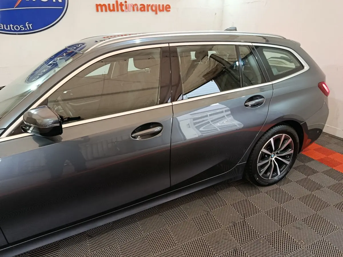 Vue latérale côté gauche d'une BMW Série 3 Touring gris clair avec jantes alliage et vitres teintées.