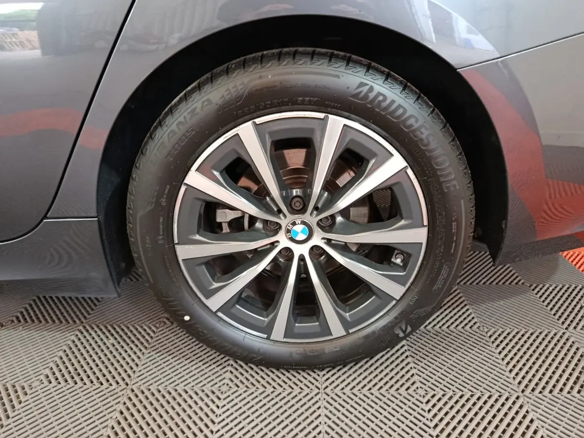 Gros plan sur la roue arrière droite gris clair d'une BMW Série 3 316d avec jante alliage et pneu Bridgestone.