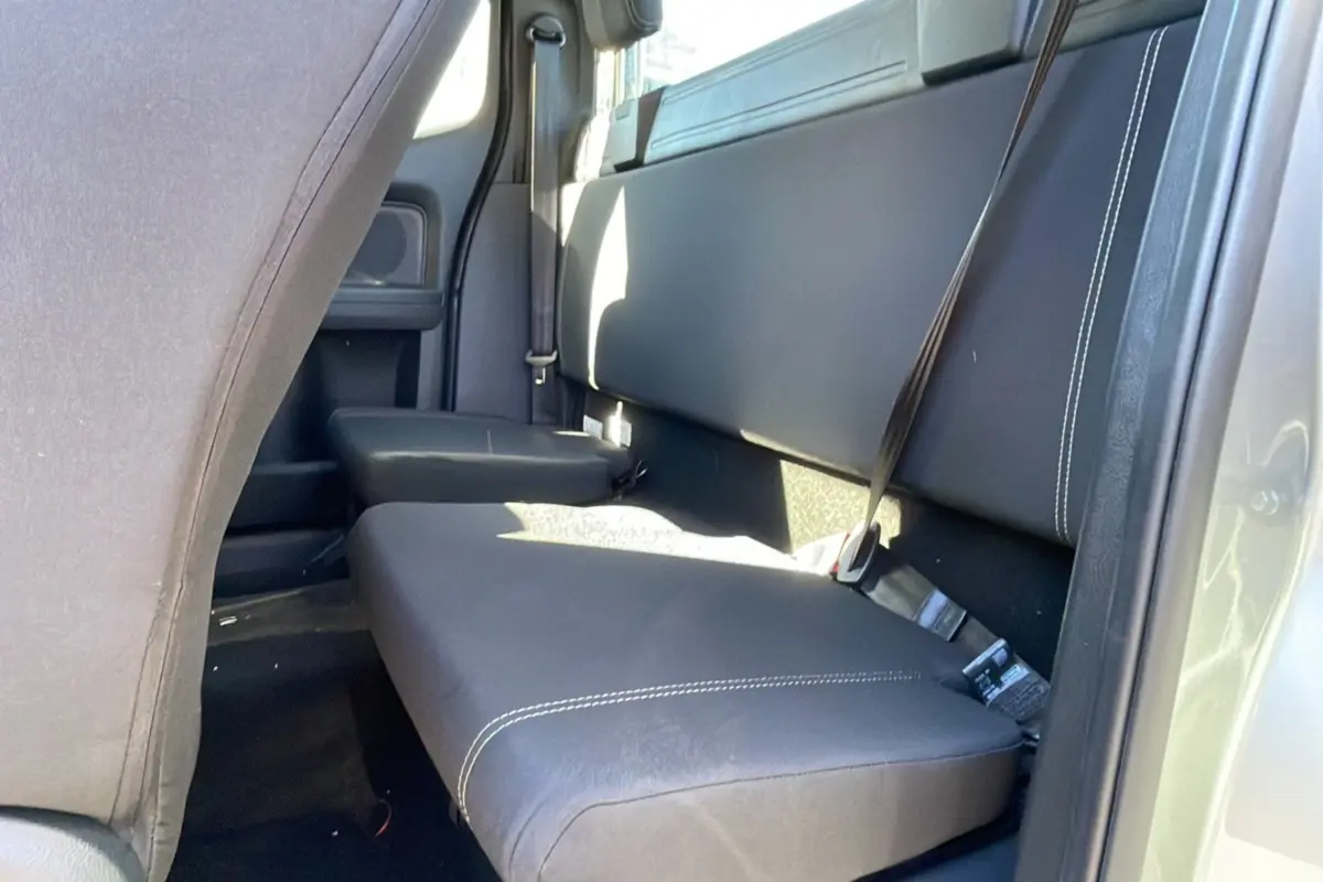 Vue intérieure arrière côté droit du Ford Ranger gris iconic, montrant la banquette en cuir noir avec surpiqûres blanches.