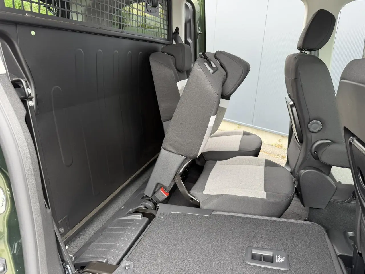 Vue latérale intérieure du Citroën Berlingo Multispace vert Sirkka montrant les sièges arrière indépendants escamotables.