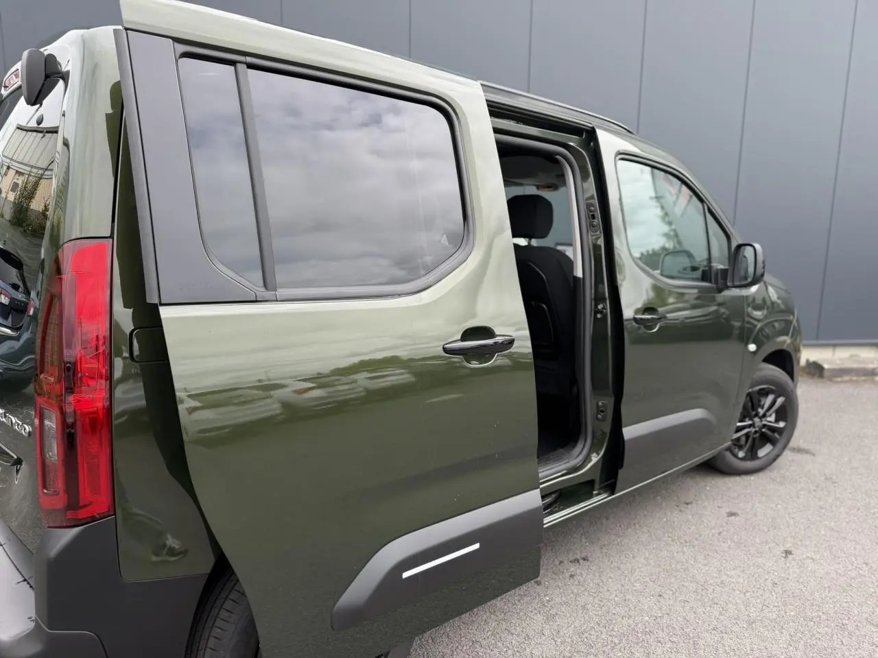 Vue 3/4 arrière droite du Citroën Berlingo Multispace vert Sirkka avec porte latérale coulissante ouverte.