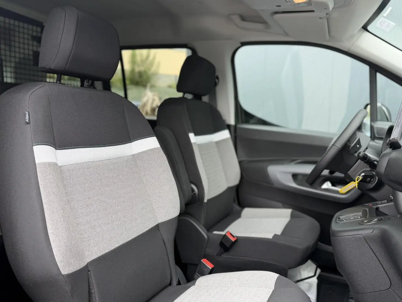 Vue intérieure côté droit du Citroën Berlingo Multispace 2026, sièges tissu gris et noir avec volant multifonctions.