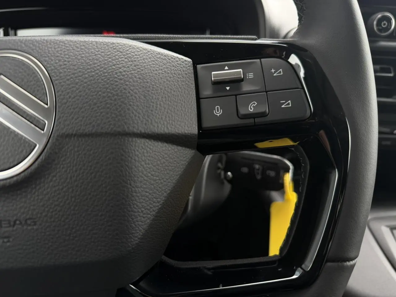 Gros plan sur les commandes multifonctions du volant cuir noir du Citroën Berlingo Multispace 2026.