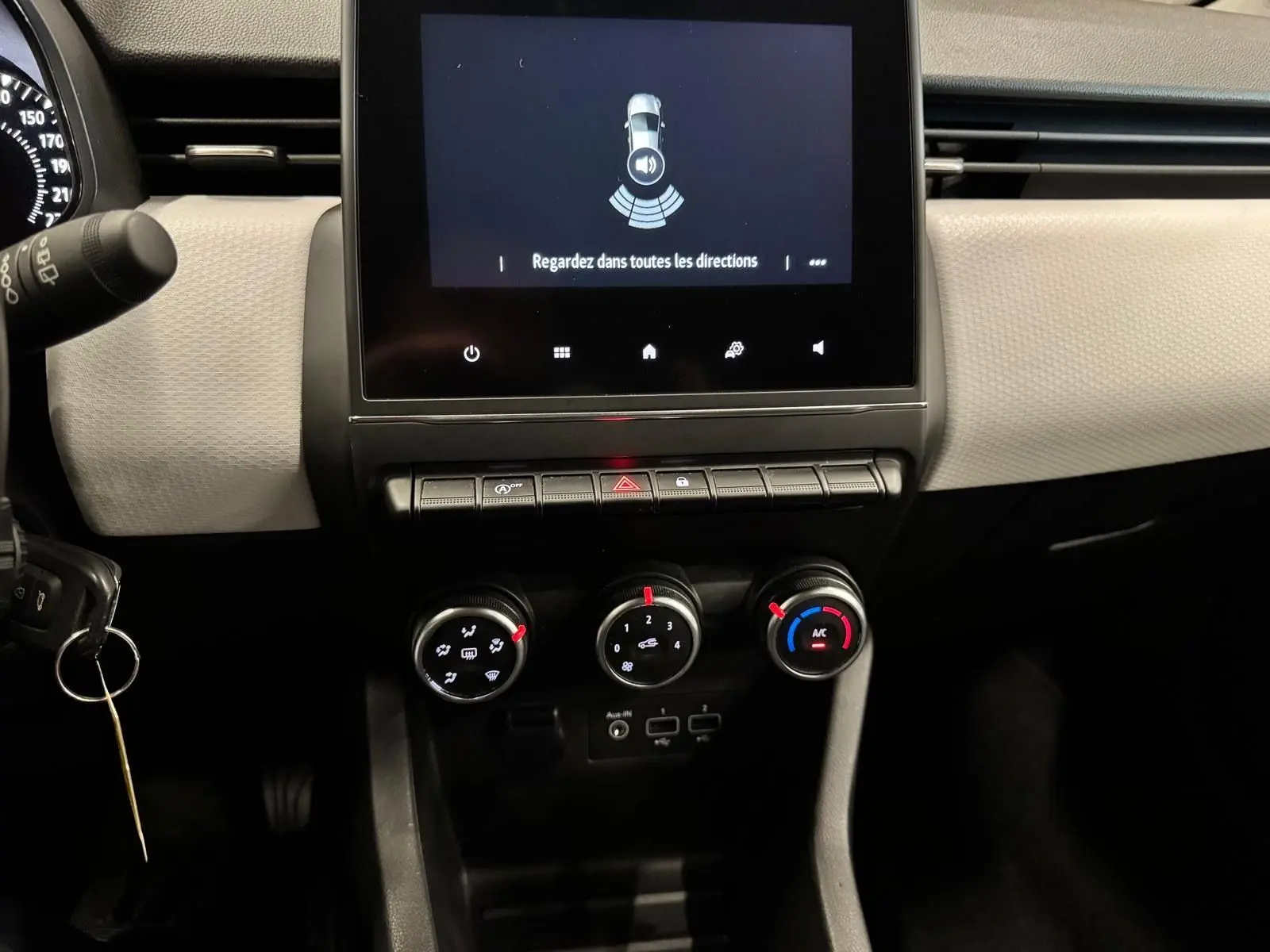 Vue rapprochée du tableau de bord de la Renault Clio V 2022, avec écran tactile et commandes de climatisation.