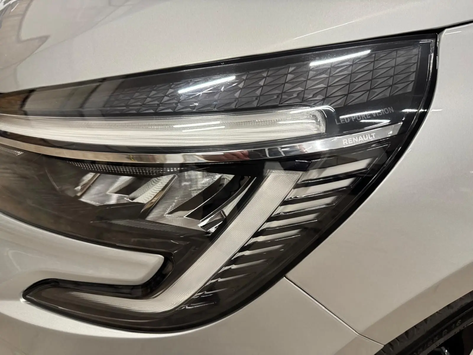 Gros plan sur le phare avant droit gris aluminium de la Renault Clio V 2022 avec signature LED distinctive.