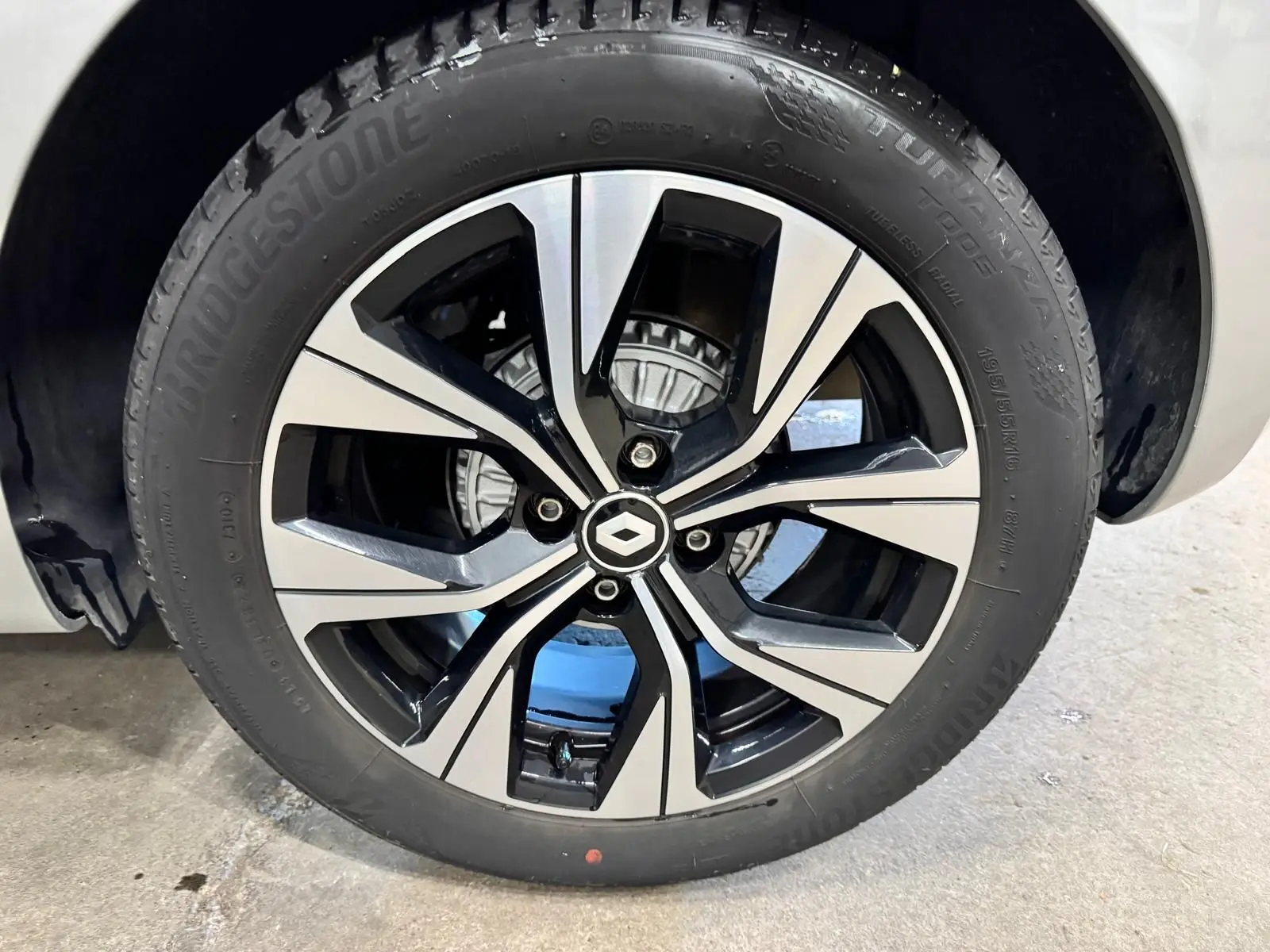 Gros plan sur la jante alliage biton 16 pouces de la Renault Clio V gris aluminium, avec logo Renault au centre.