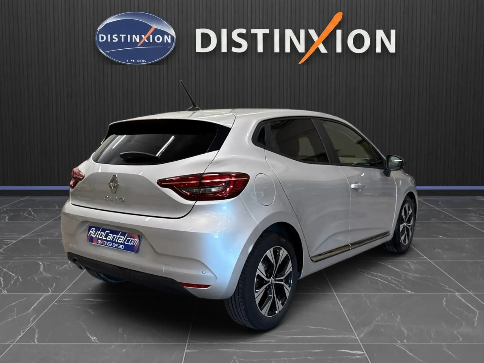 Renault Clio V gris aluminium vue 3/4 arrière droit, feux LED et jantes alliage bicolores visibles.