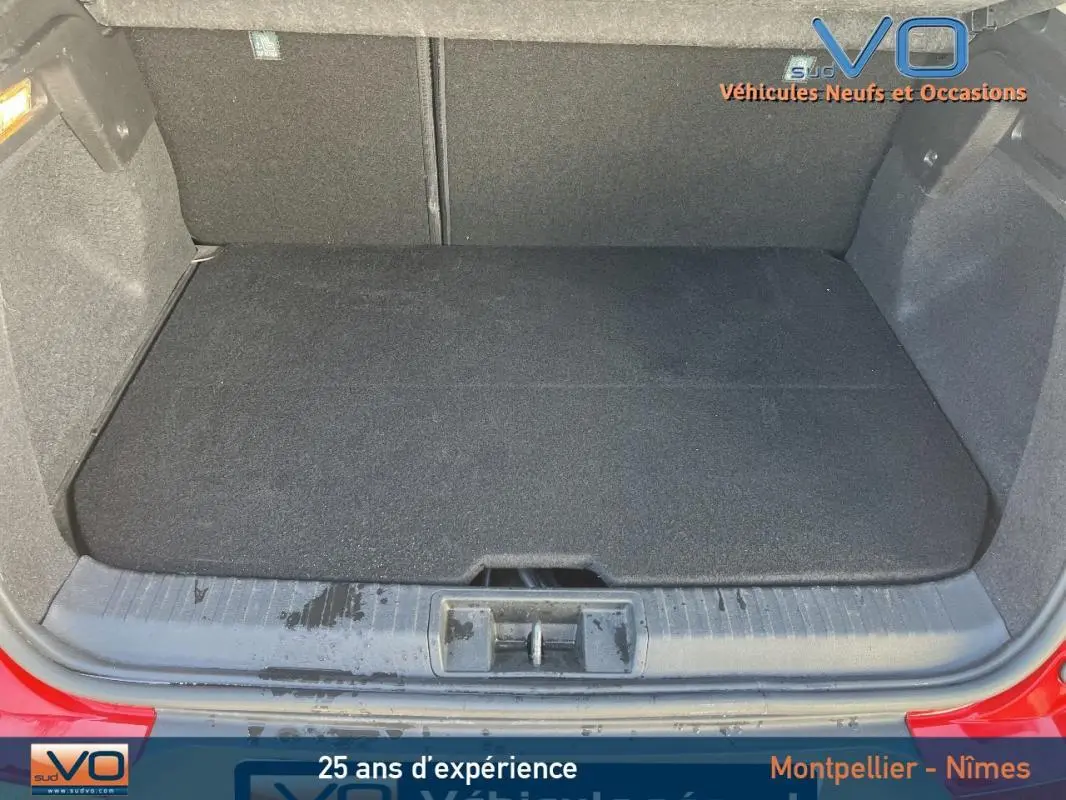 Coffre ouvert du Renault Captur E-Tech Plug-in rouge, montrant l'espace de chargement propre et bien fini.