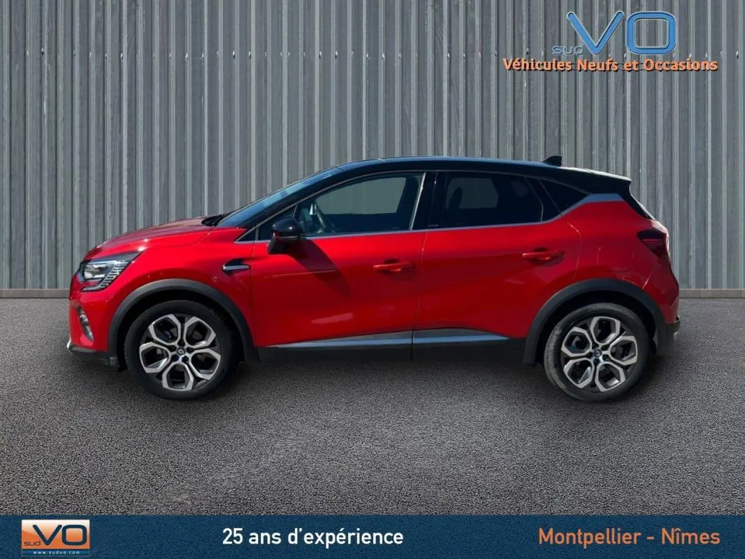 Profil côté gauche d'un Renault Captur rouge E-Tech Plug-in 160 Intens avec jantes alliage 18 pouces sur fond urbain.