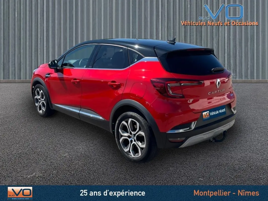 Vue 3/4 arrière gauche d'un Renault Captur rouge E-Tech Plug-in 160 Intens avec jantes alliage 18 pouces et vitres surteintées.