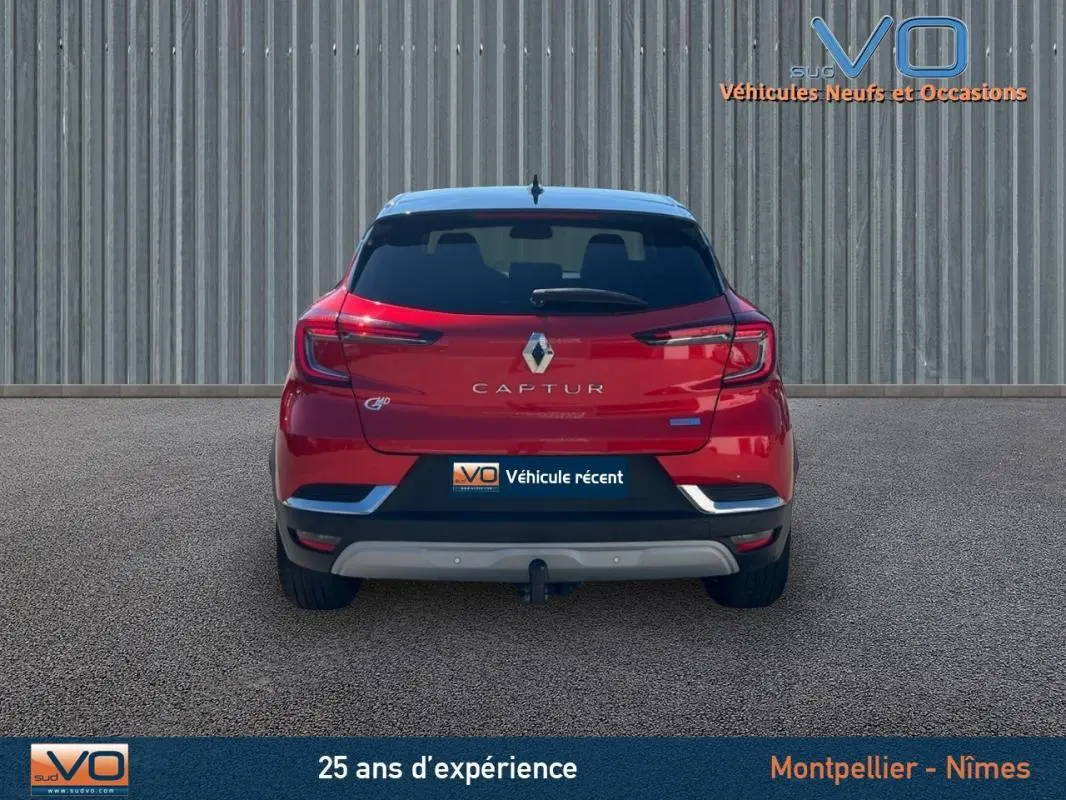 Vue arrière d'un Renault Captur rouge E-Tech Plug-in 160 Intens 2020 avec vitres surteintées et attelage visible.