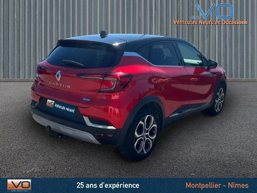 Vue 3/4 arrière droite d'un Renault Captur E-Tech Plug-in rouge avec jantes alliage 18 pouces et vitres surteintées.