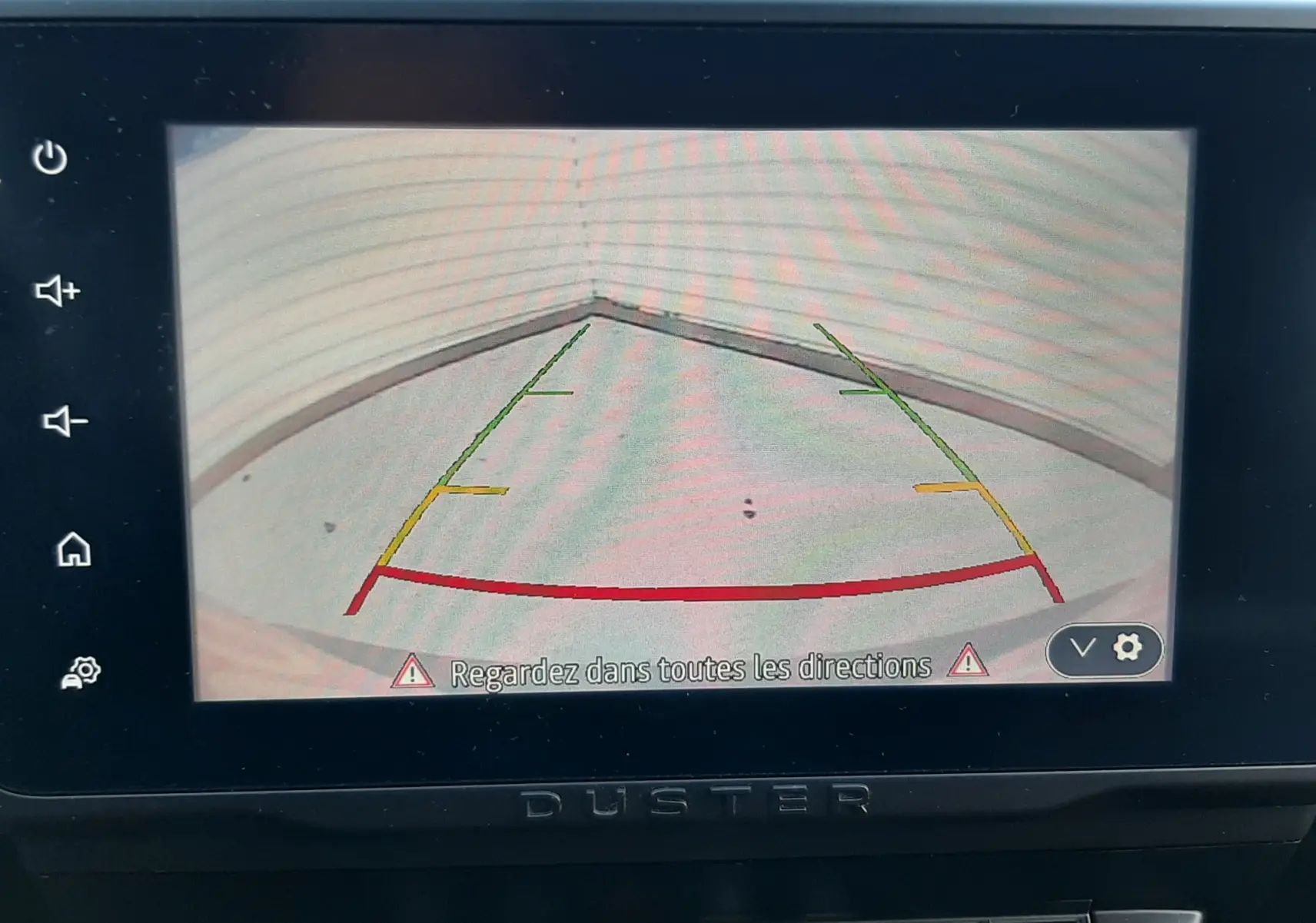 Écran de caméra de recul du Dacia Duster bleu 2023, vue intérieure centrée sur l'affichage et les commandes.