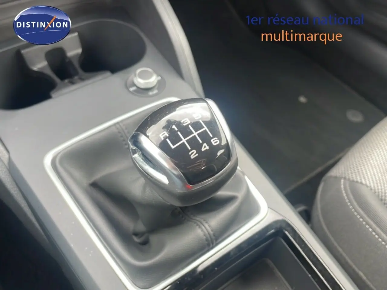 Gros plan sur le levier de vitesses manuel noir de l'Audi Q2 30 TDI S-Line, avec console grise et siège tissu visible.