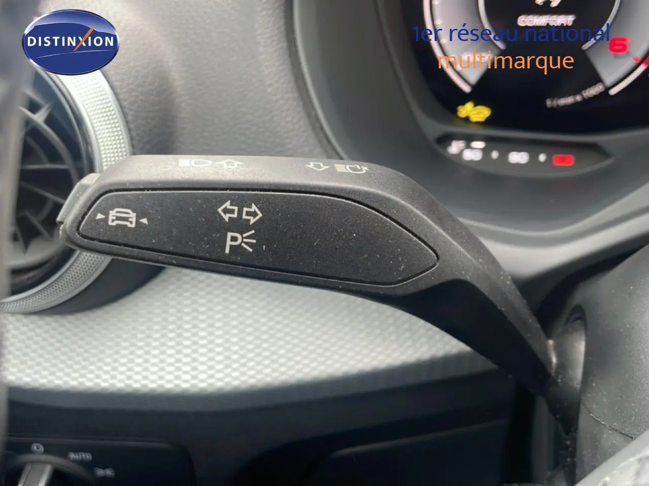 Gros plan sur la commande de clignotant à gauche dans l’habitacle noir du Audi Q2 30 TDI S-Line 2025.